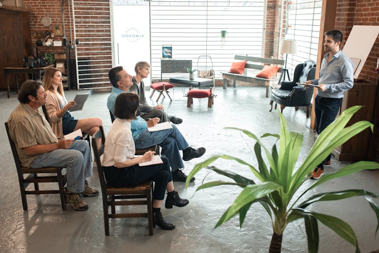 Diverse group of adults engaged in a workshop session inside a trendy loft.